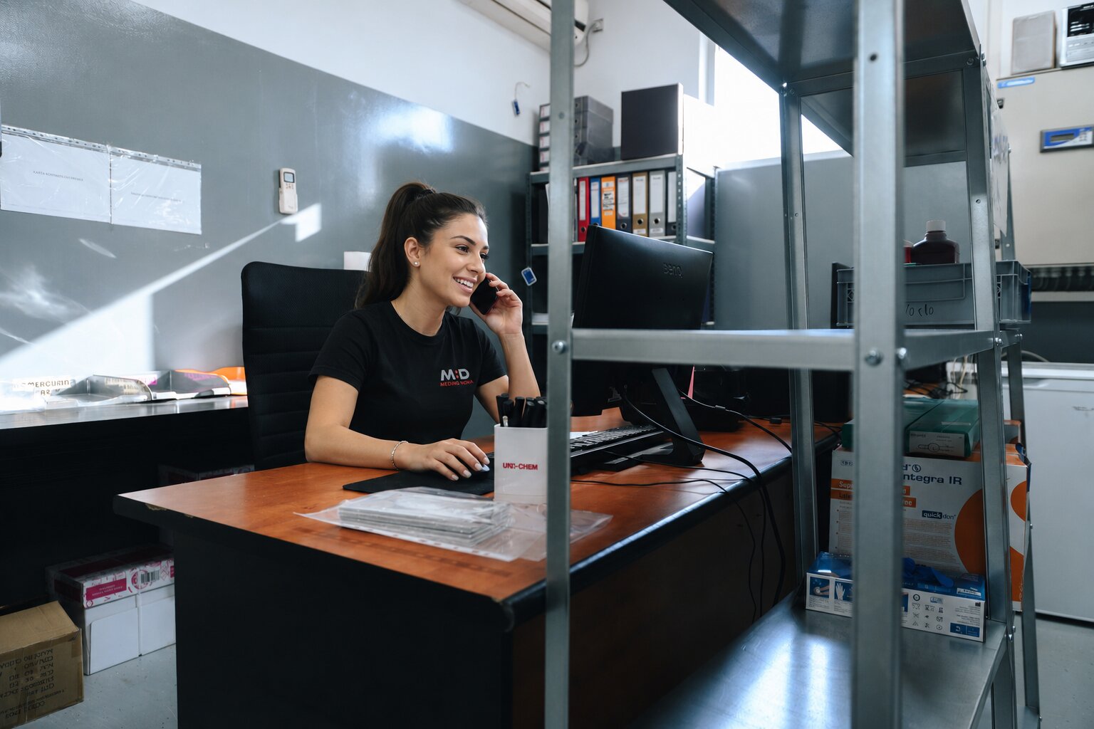 Zaposlena telefonira za svojim stolom